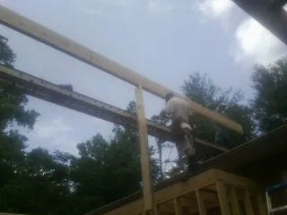 Carpenter setting a ridge beam over a new addition frame — Ice Dam Removal by Roofing Brothers in Hermanville