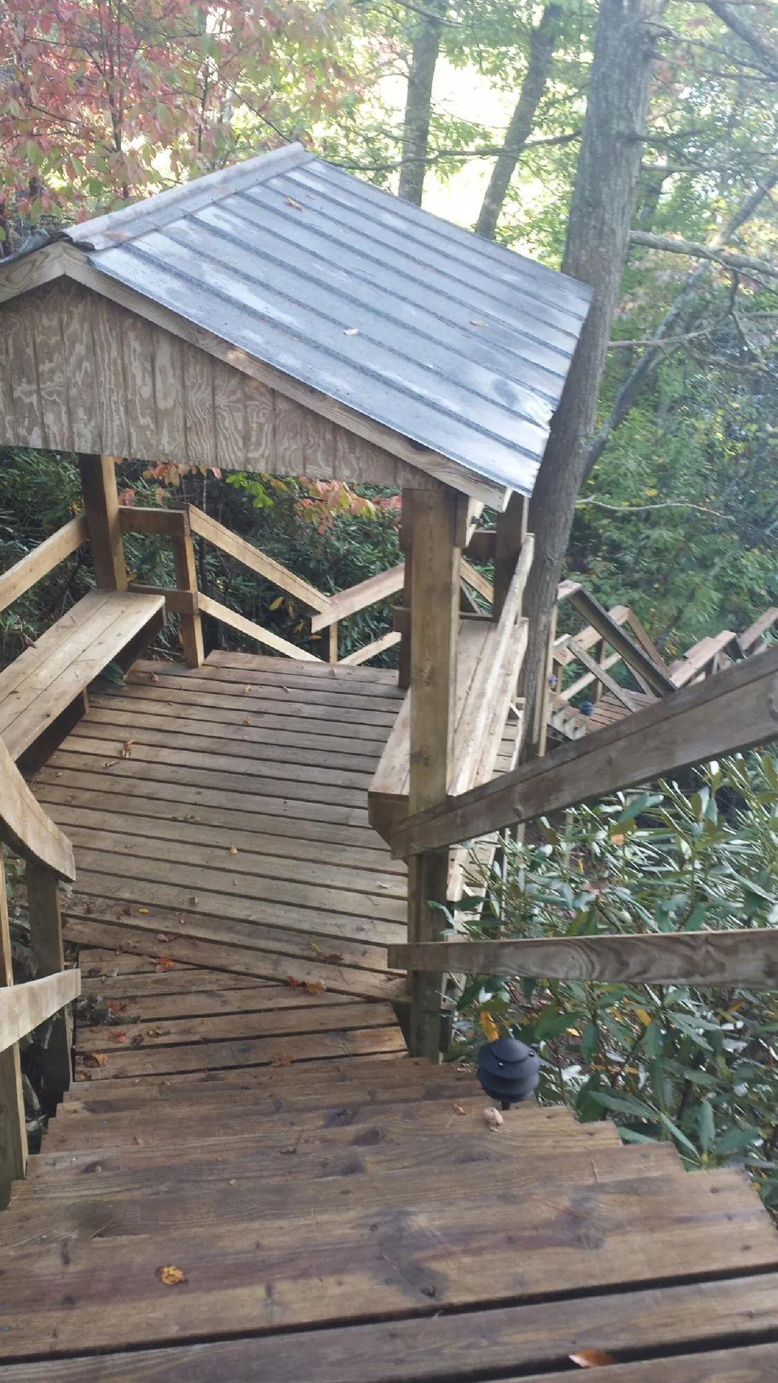 Metal roofed shelter over wooden steps on a wooded walkway — Skylight Repair & Installation work by our crew in Hermanville