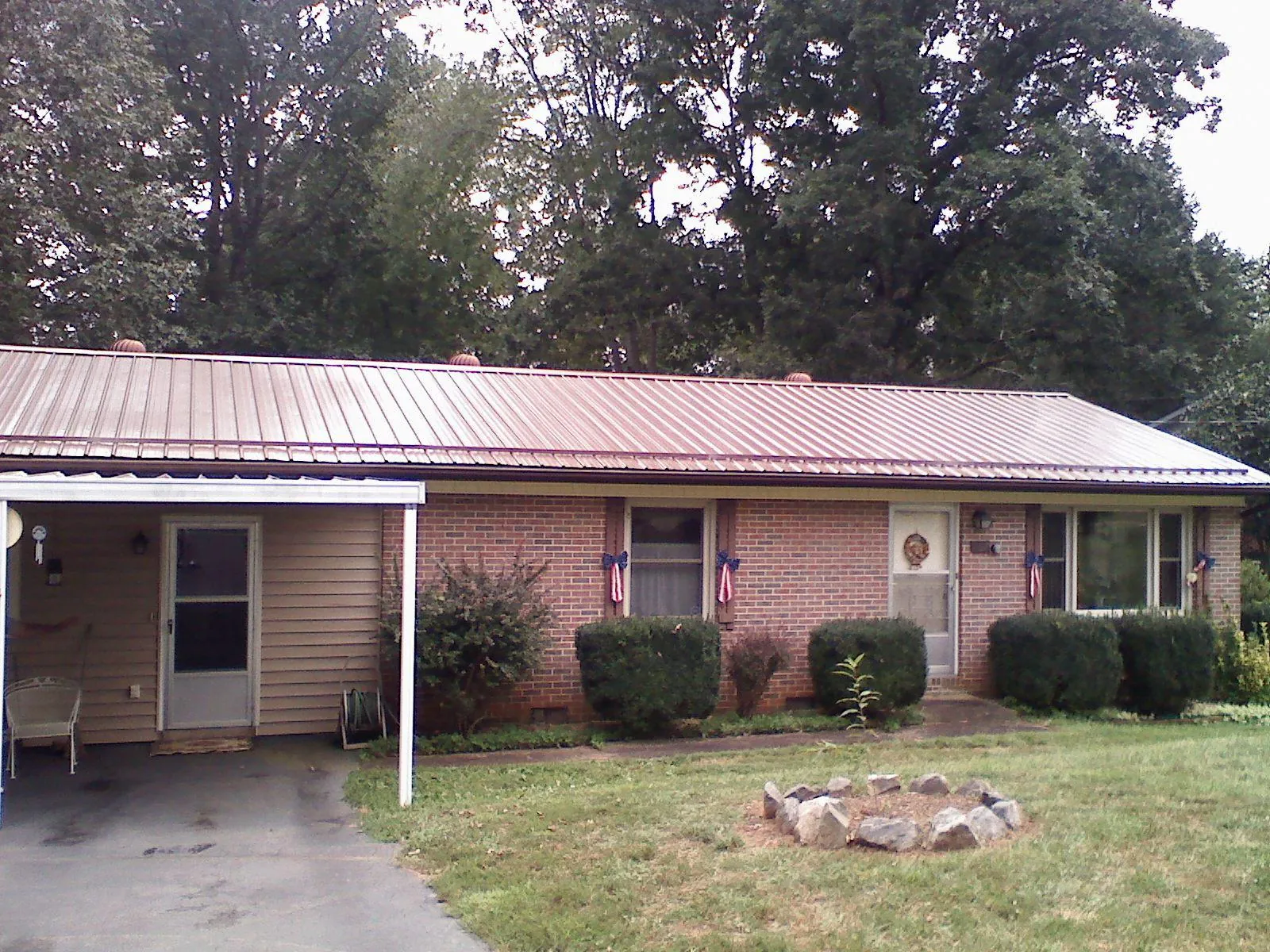 Bronze metal roof and carport on a brick ranch home — Roof Repair work by our crew in Hermanville